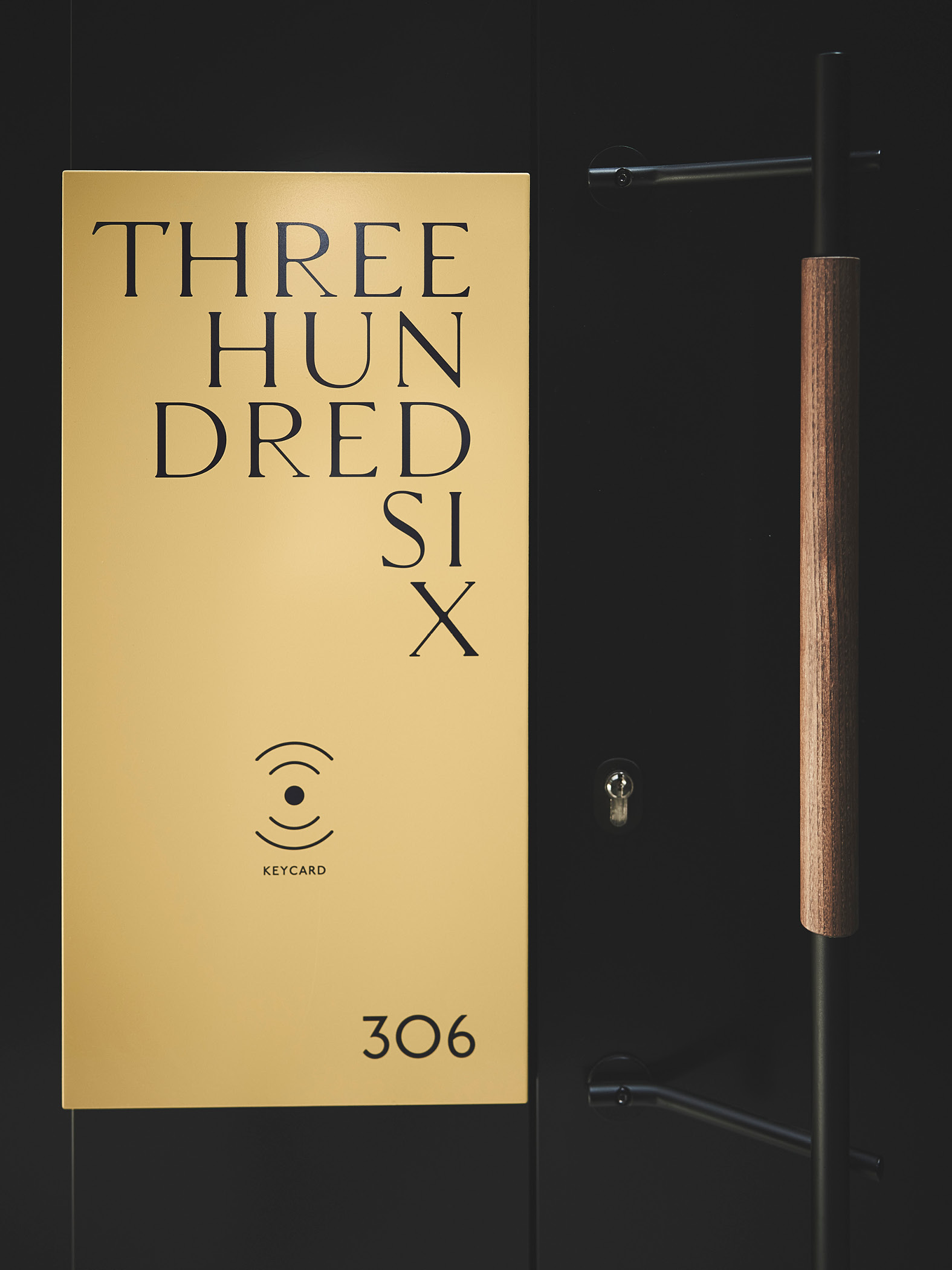 Schwarze Tür mit gelbem Schild 'Three Hundred Six' und Keycard-Symbol.