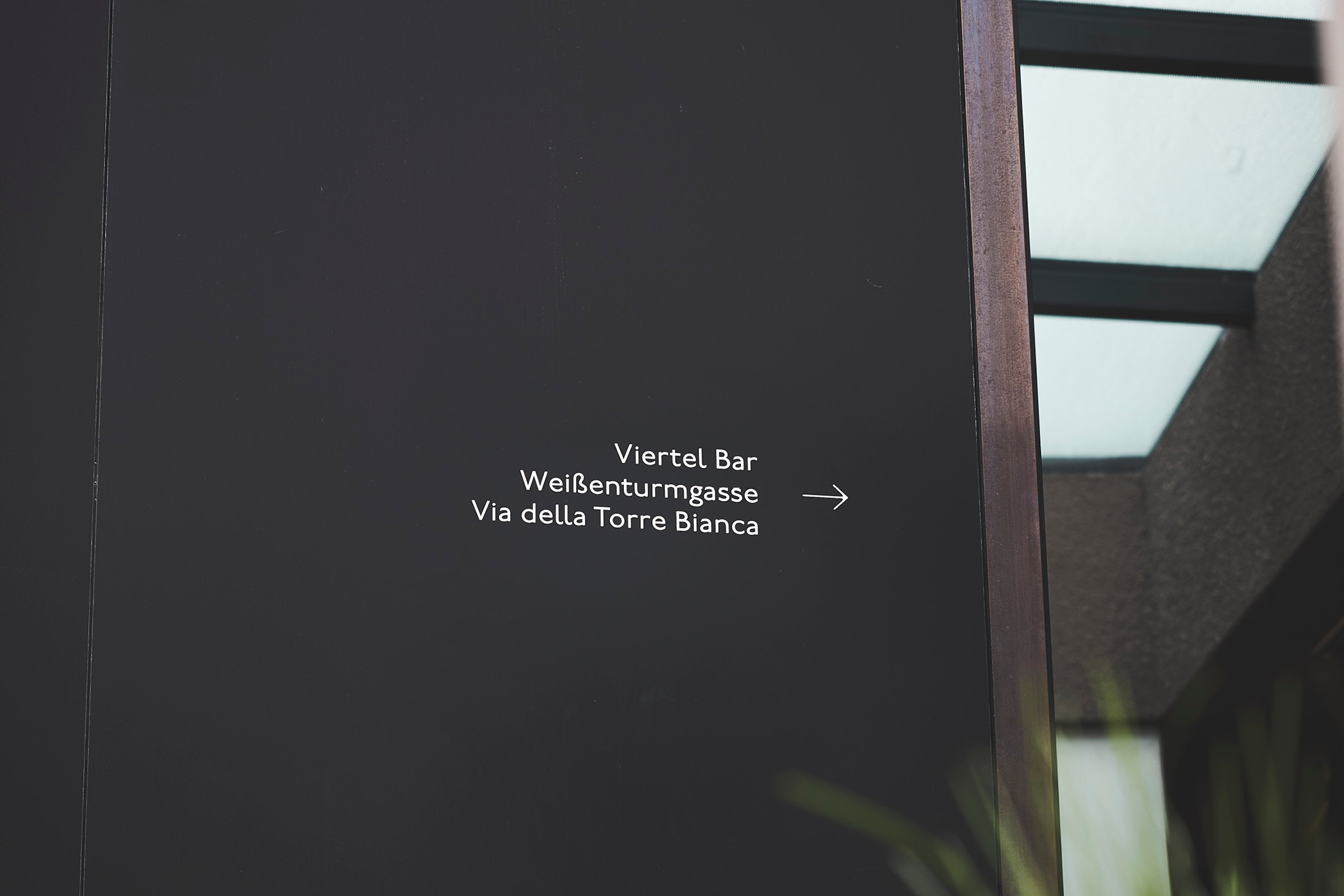 Schwarzes Schild mit Wegbeschreibung zur Viertel Bar, Weißenturmgasse.