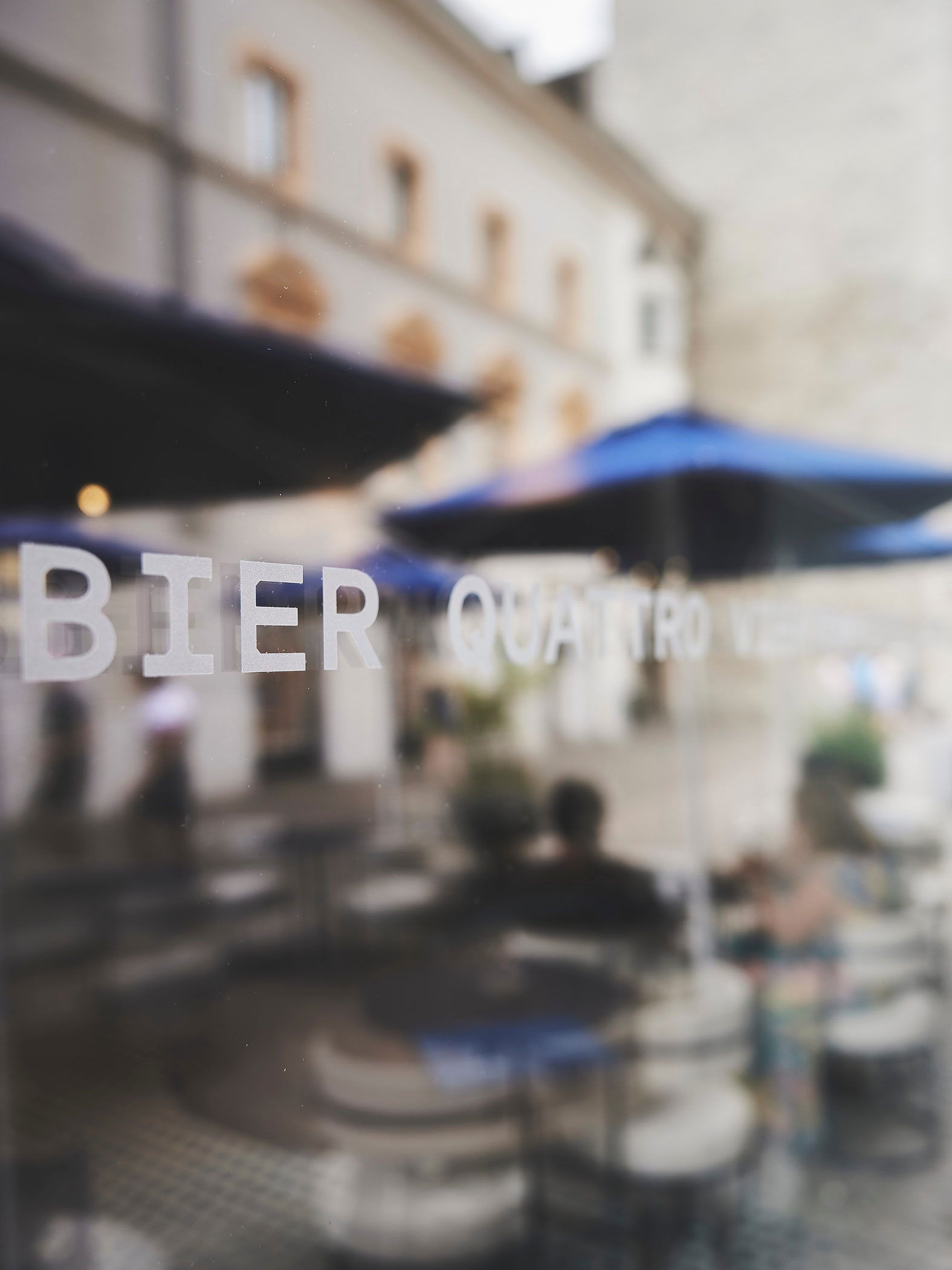 Spiegelung eines Cafés mit Schriftzug "Bier" auf Glas