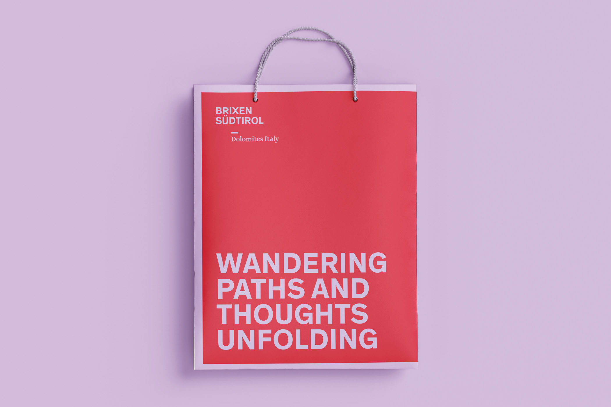 Rote Papiertüte mit Aufschrift 'Wandering paths and thoughts unfolding', Brixen Südtirol.
