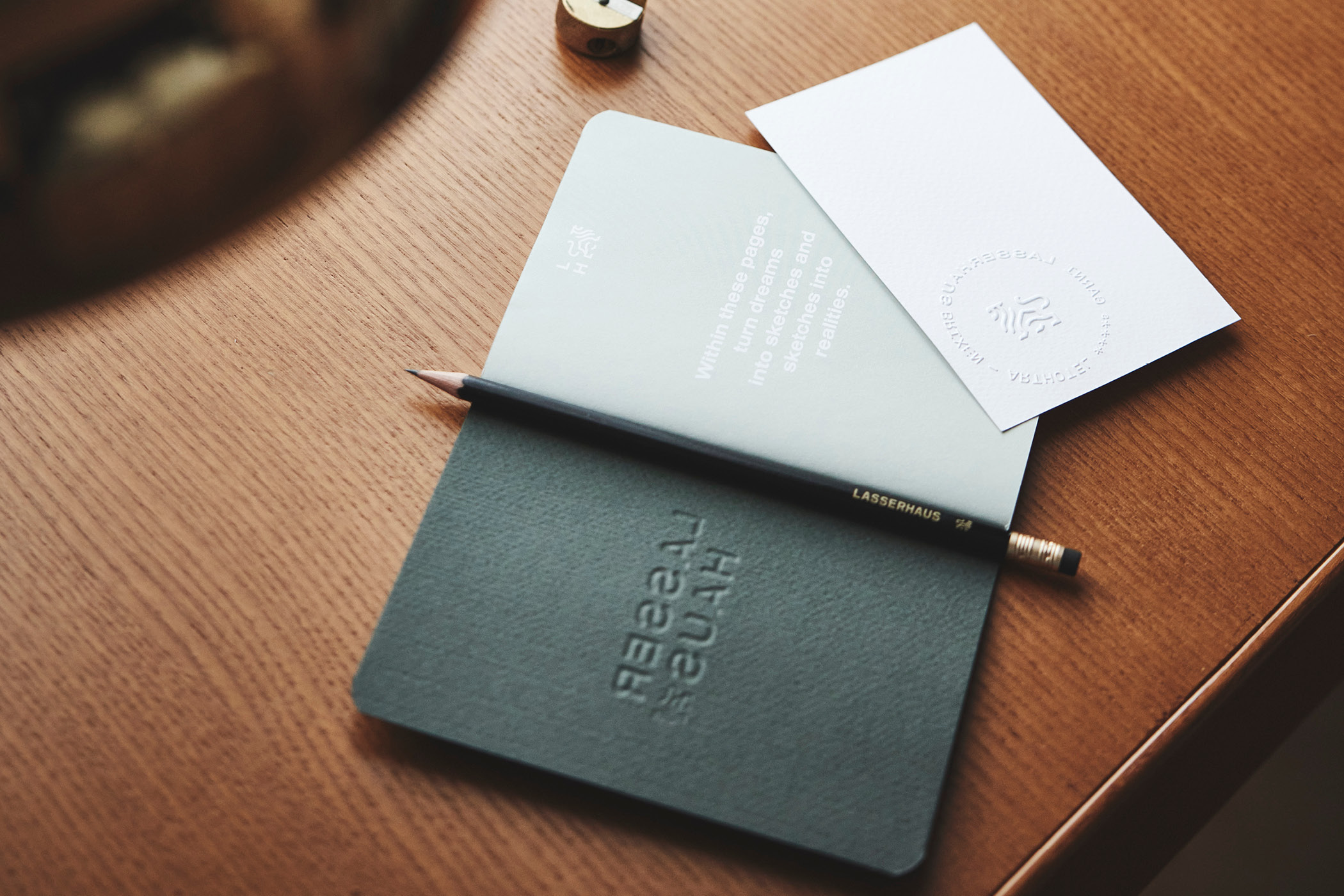 Notizbuch, Bleistift und geprägte Karte auf Holztisch