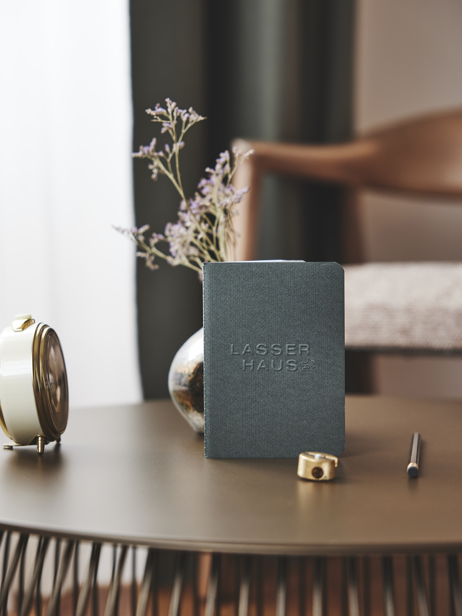 Notizbuch mit Lasser Haus Logo auf dekorativem Tisch