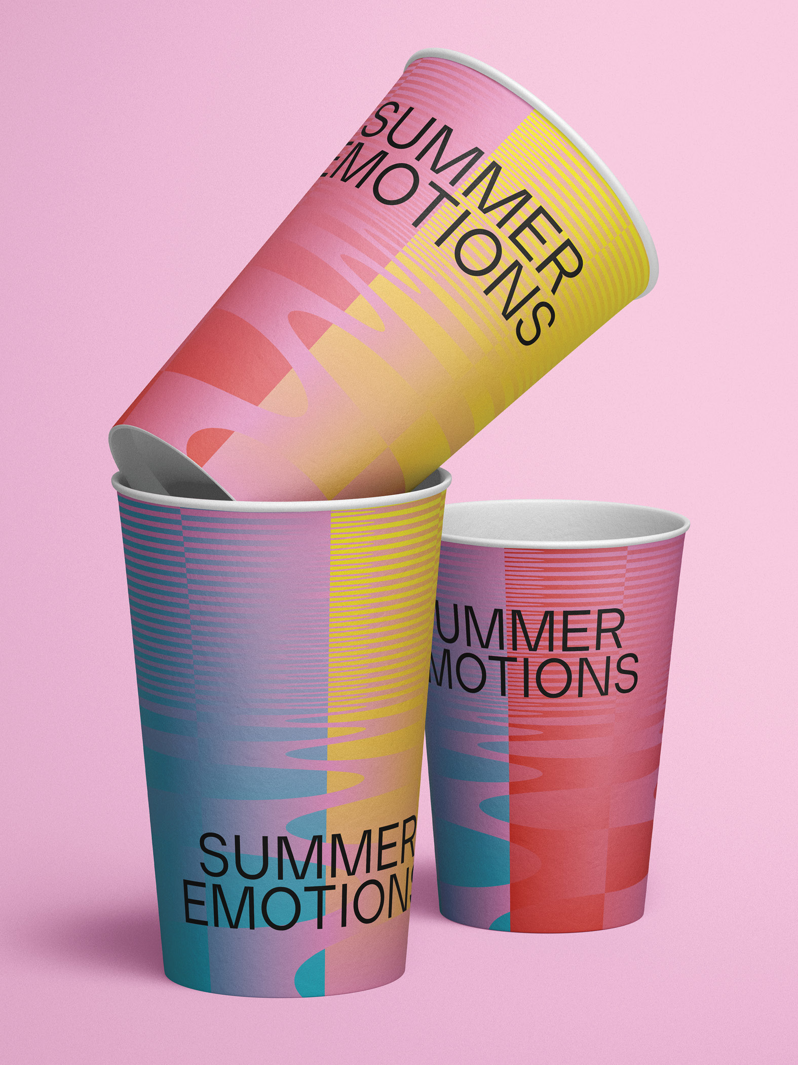 Drei bunte Pappbecher mit der Aufschrift 'Summer Emotions' auf rosa Hintergrund.
