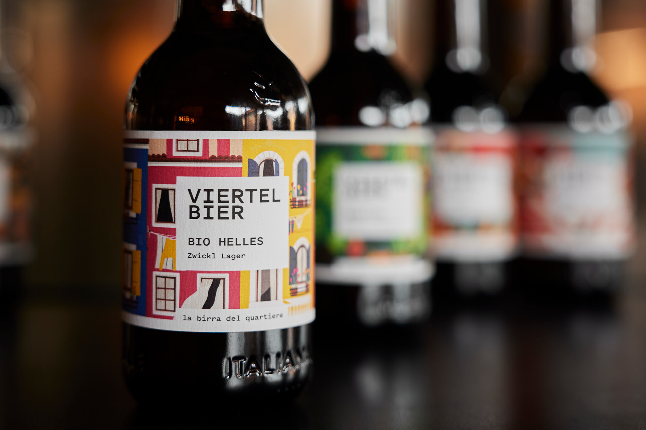 Viertel Bierflasche Bio Helles mit buntem Etikett im Vordergrund