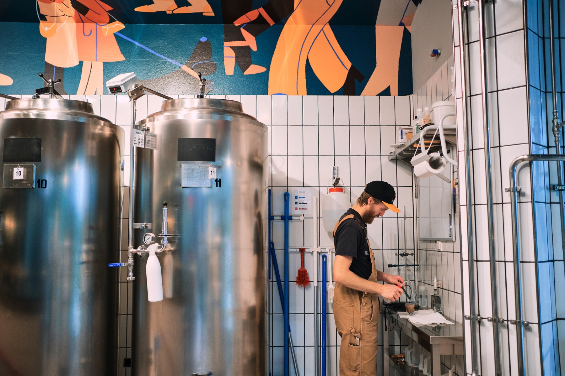 Brauer in industrieller Brauerei mit großen Metalltanks