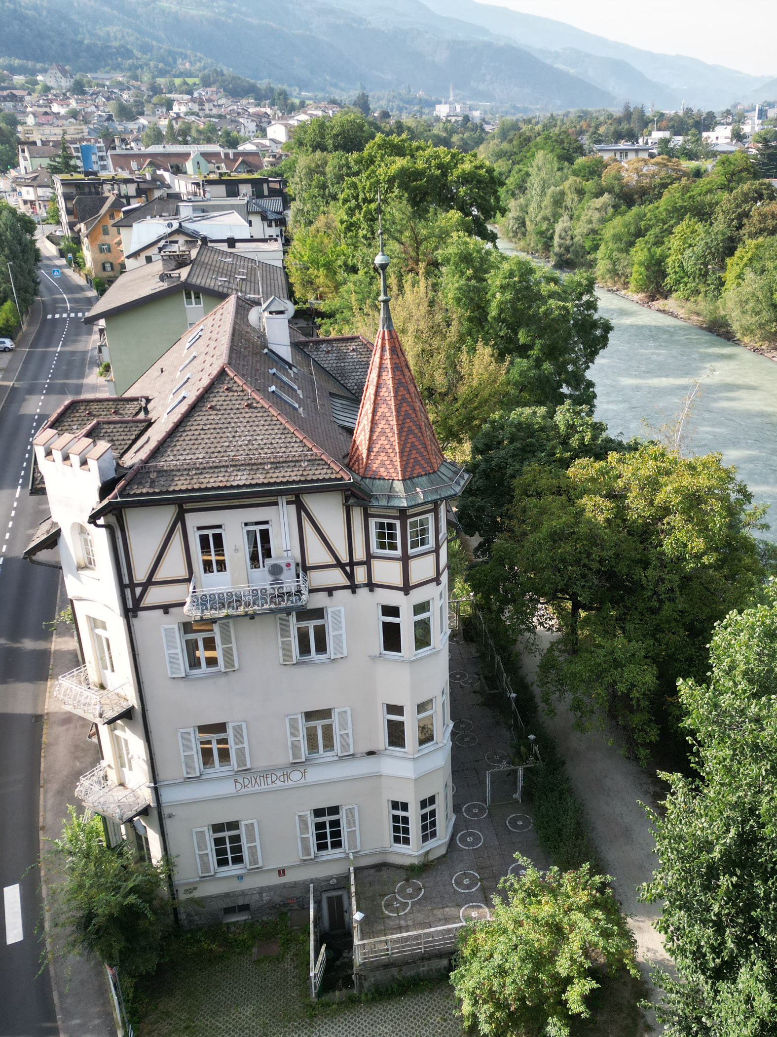 Historisches Gebäude Brixner Hof an Flussufer und Straße