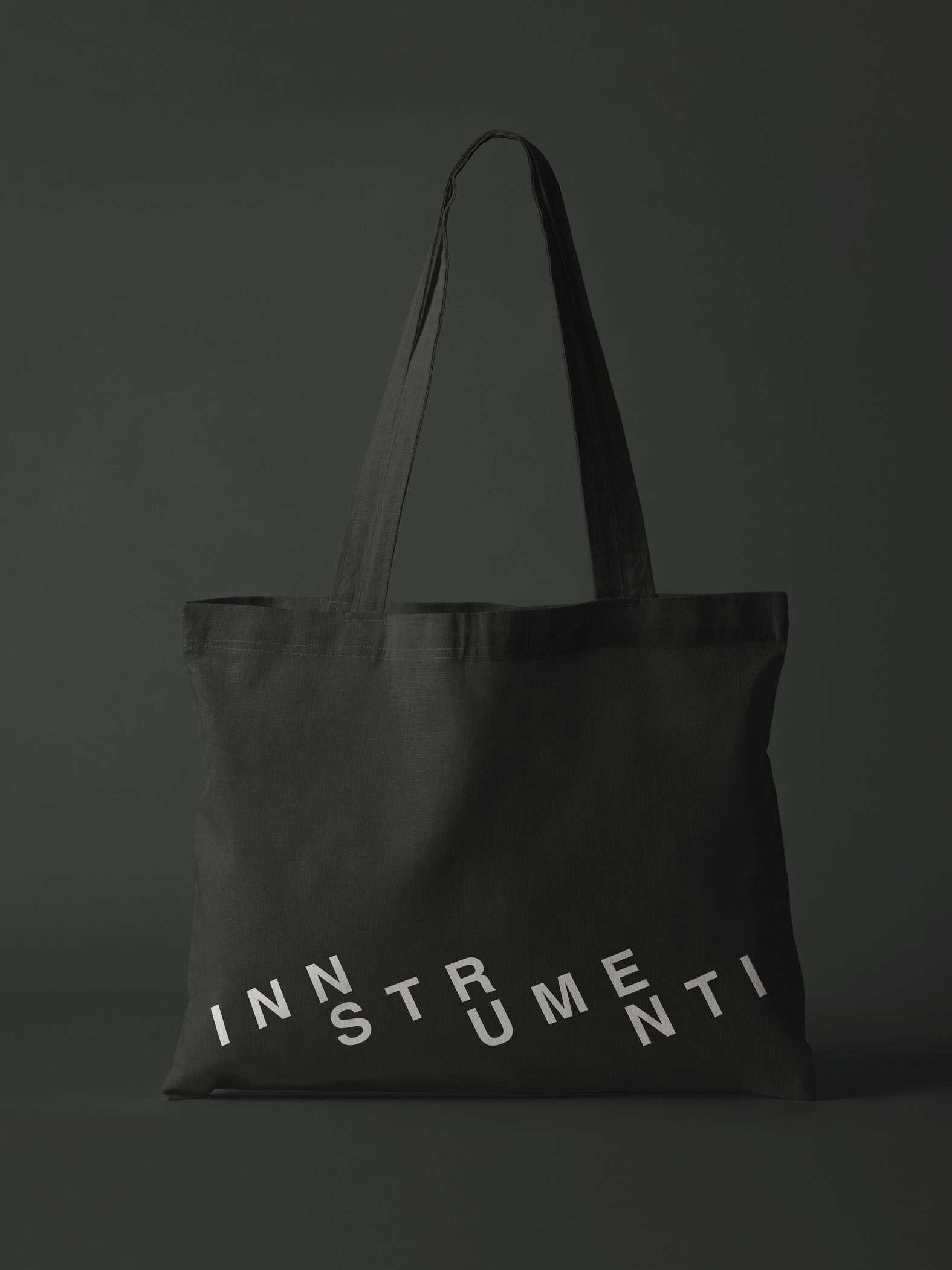 Schwarze Stofftasche mit dem Schriftzug 'INNSTRUMENTI' auf dunklem Hintergrund.