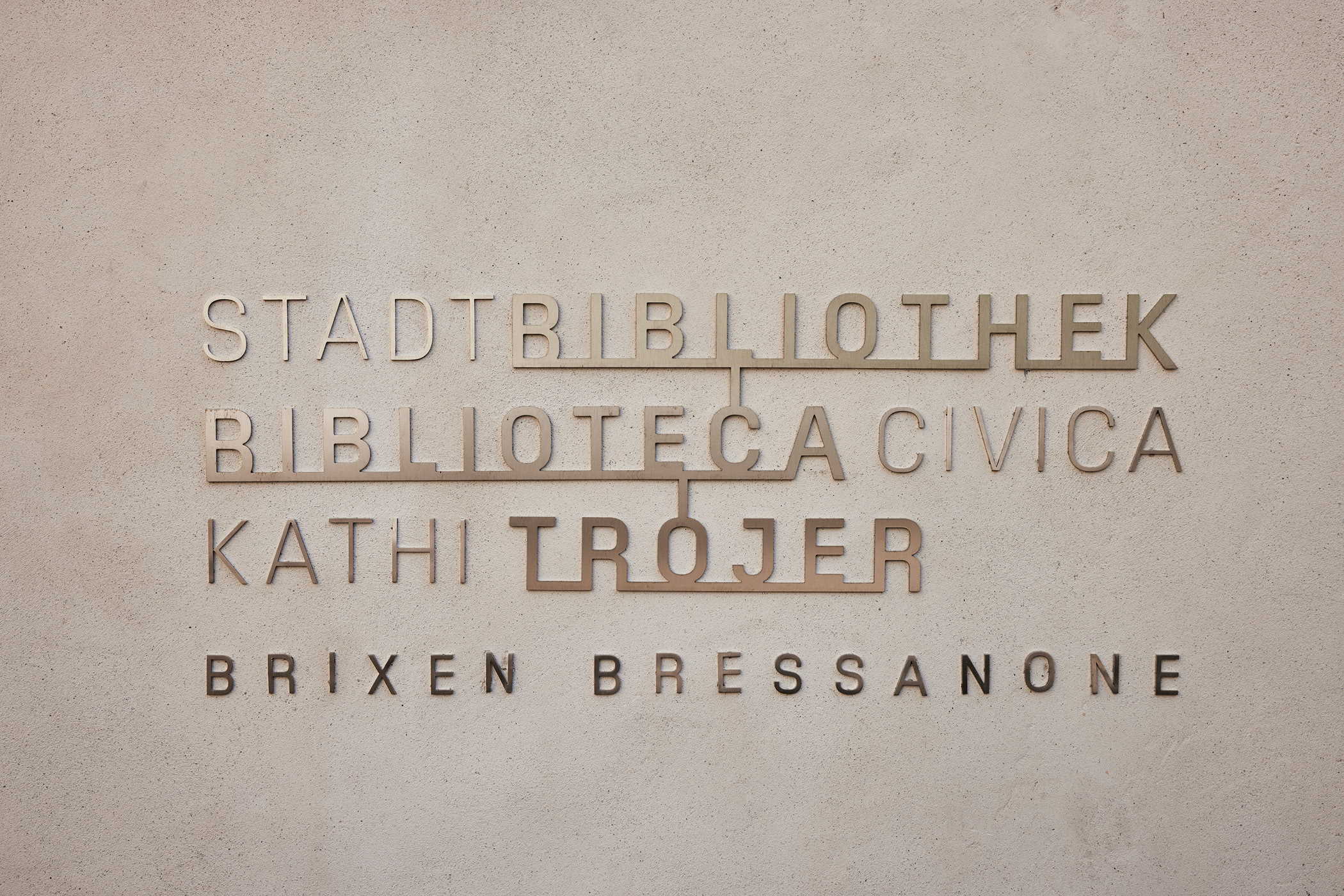 Metallschriftzug an der Wand der Stadtbibliothek Brixen