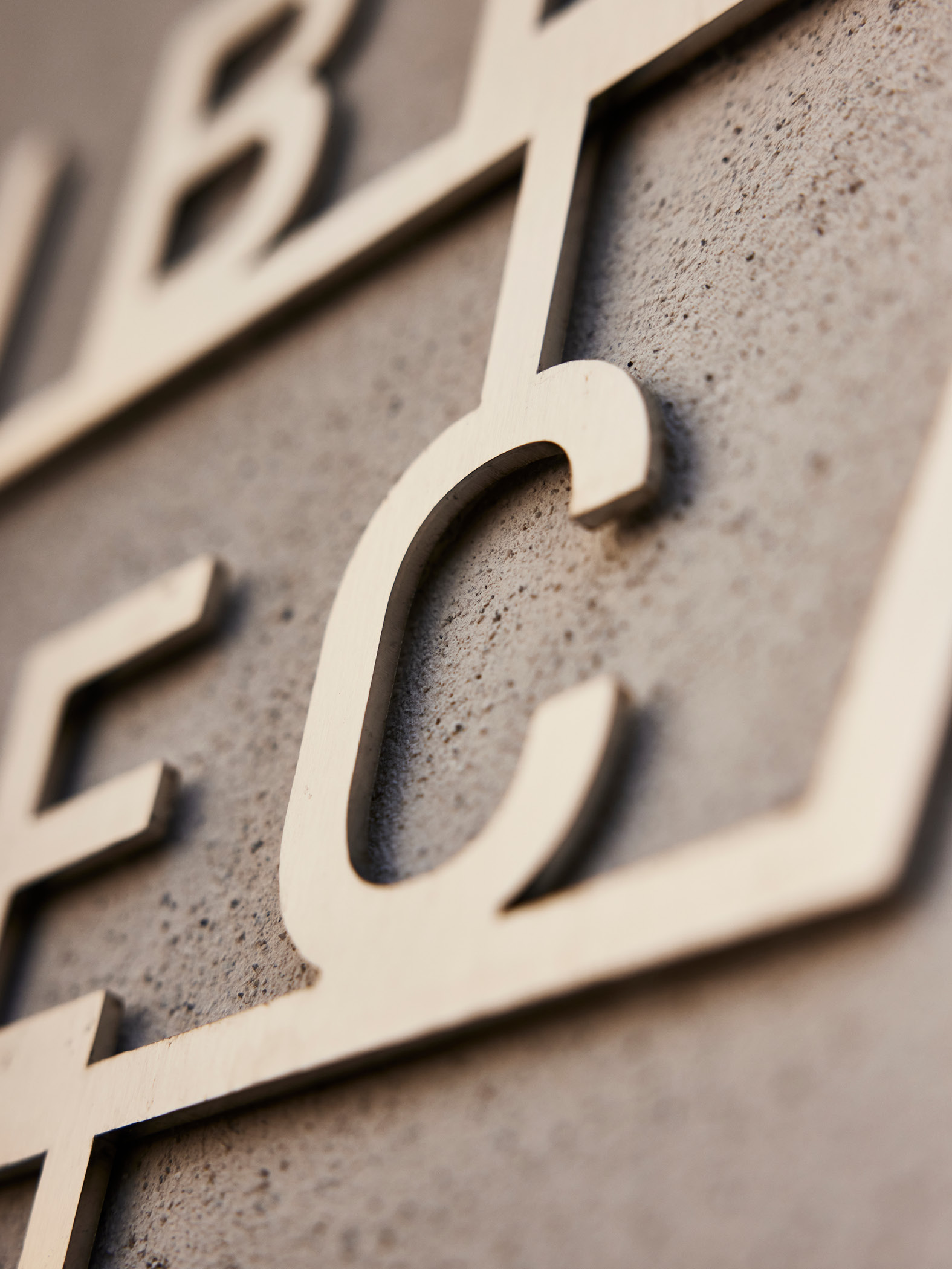 Nahaufnahme eines Metallschildes an Betonwand
