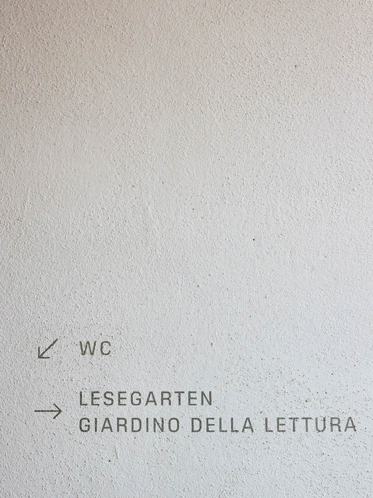 Wegweiser zur Bibliothek: WC, Lesegarten, Giardino della Lettura