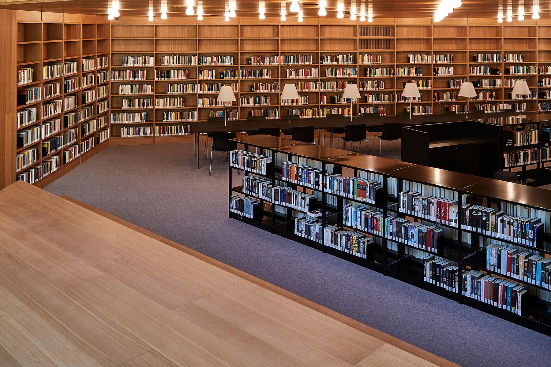 Moderne Bibliothek mit Holzeinrichtung und Lesetischen